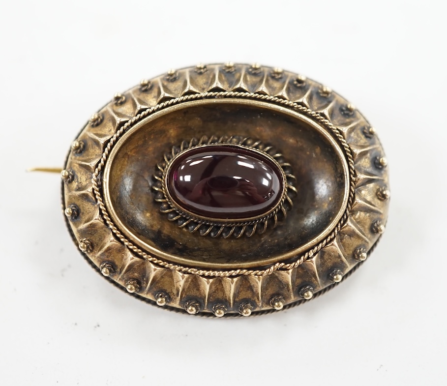 A Victorian yellow metal and single stone oval cabochon garnet set oval brooch, with glazed back, 33mm, gross weight 8.7 grams. Condition - fair